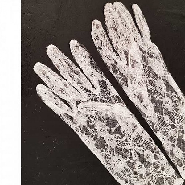 Gants de mariage élégants en dentelle blanche délicate.