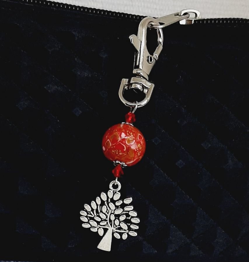 zilveren sleutelhanger met levensboom symbool en handgemaakte parel in helder rood en goud