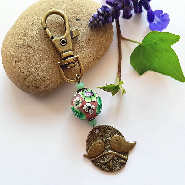 sleutelhanger medaille duo vogels bronskleurig en parelmoer bewerkt bloemmotief groen en wijnmoer meerkleurig
