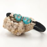 Zwarte touwarmband met dubbele schedel in blauwe stenen
