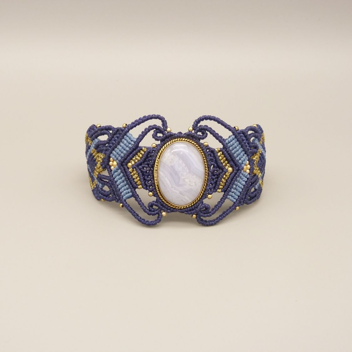 Middernachtblauwe micro-macramé armband met een lintagaat gezet in goudkleurig metaal