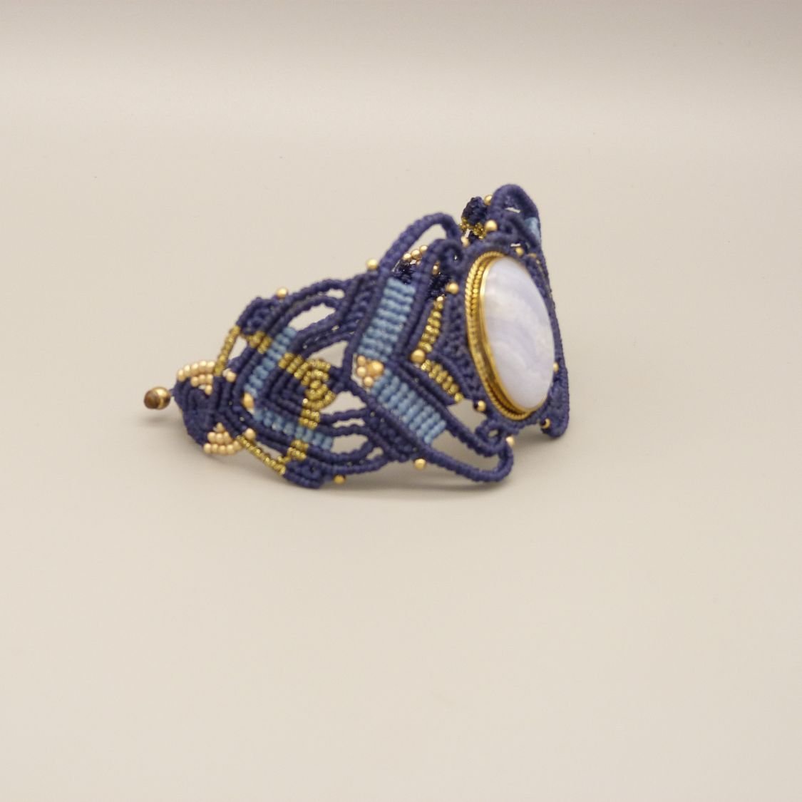 Middernachtblauwe micro-macramé armband met een lintagaat gezet in goudkleurig metaal