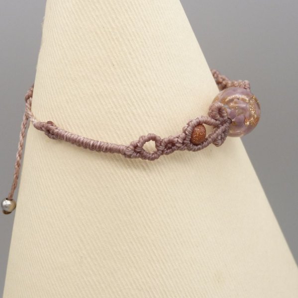 Micro macram&eacute; armband in taupe kleur met een glazen kraal
