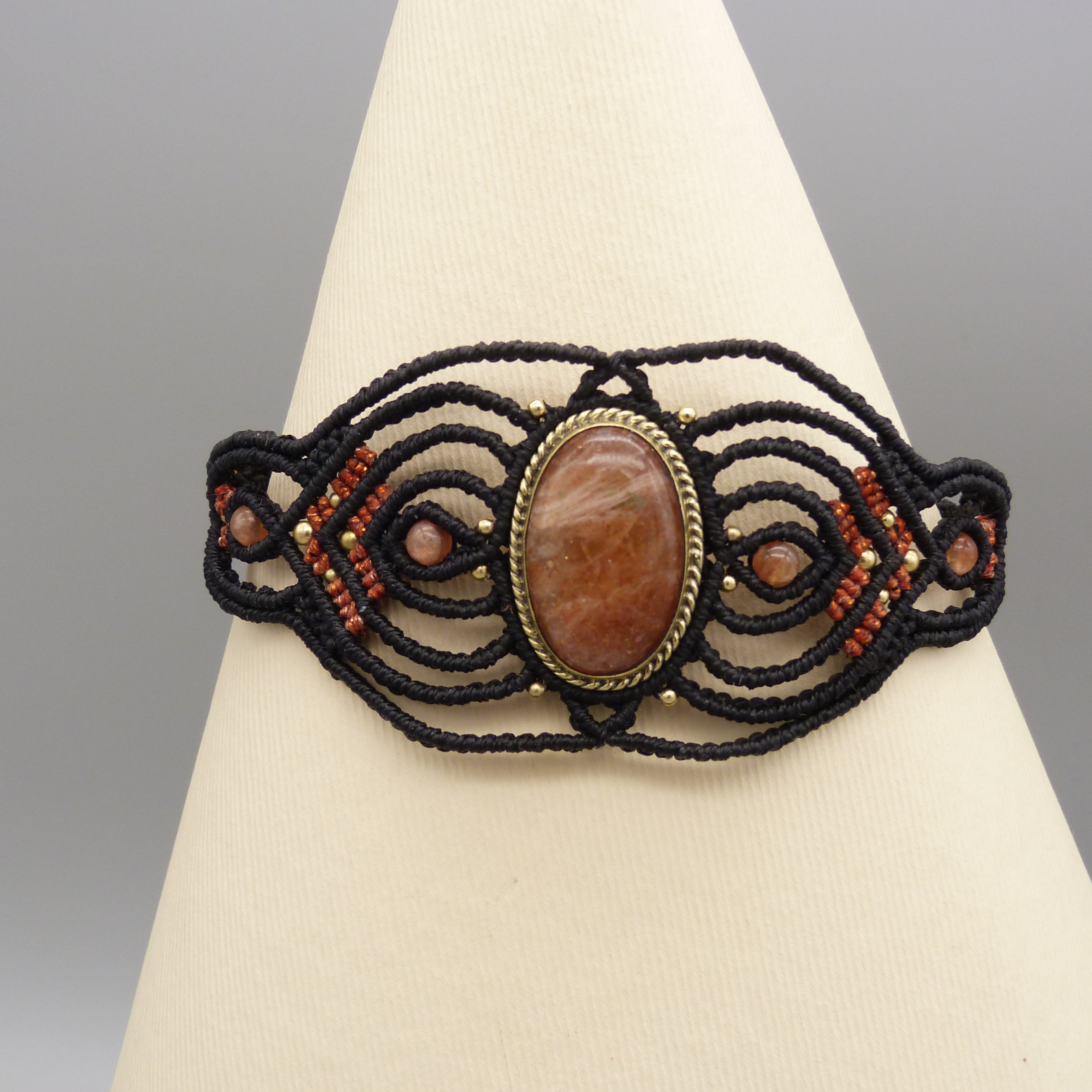 Manchette noire en micro-macramé avec une pierre de soleil