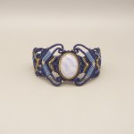 Middernachtblauwe micro-macramé armband met een lintagaat gezet in goudkleurig metaal