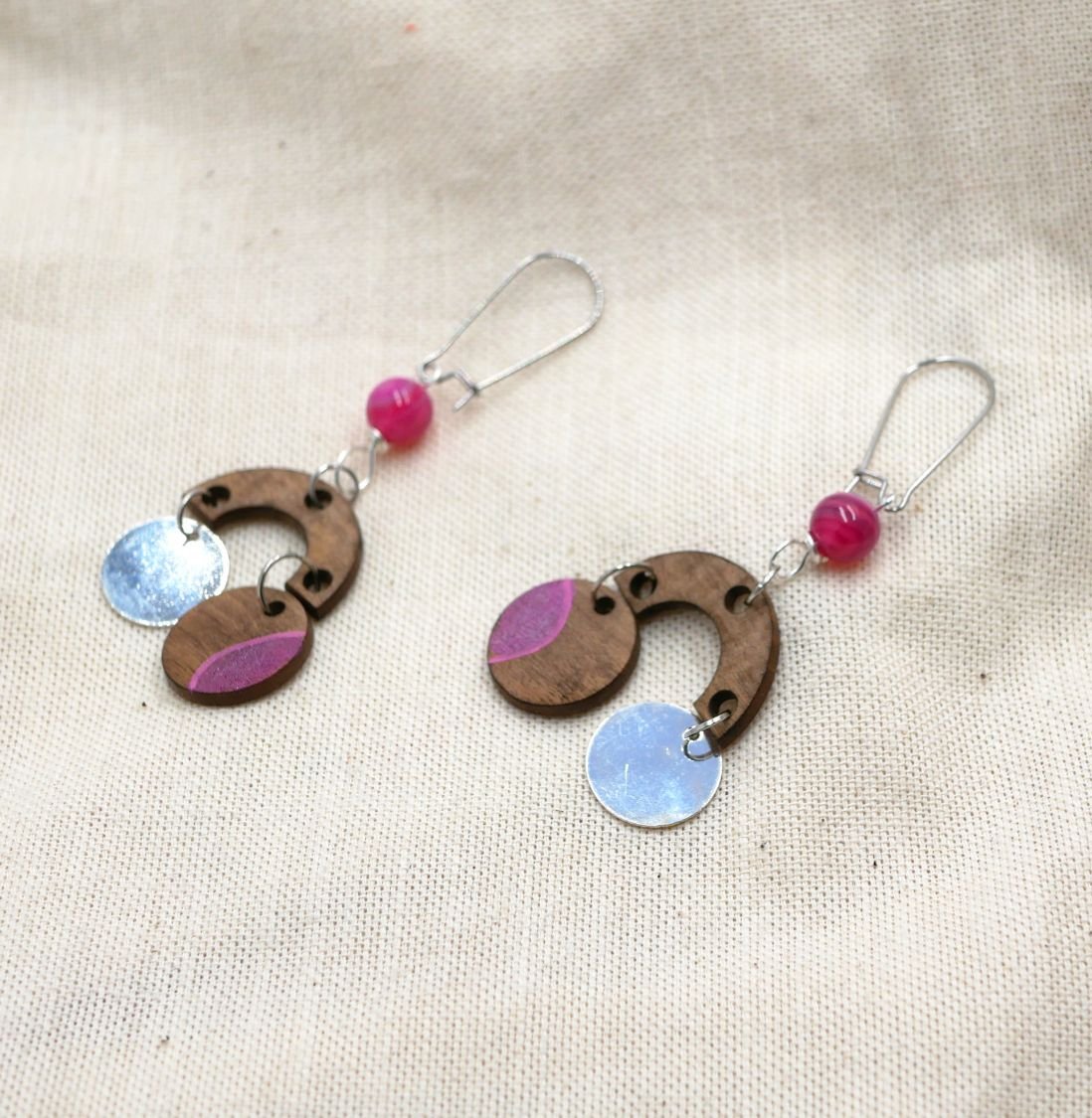Oorbellen van walnoothout met fuchsia kralen