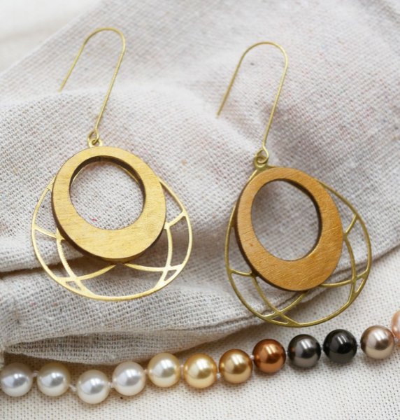 Vergulde ovale houten oorbellen aan opengewerkt messing kwastje