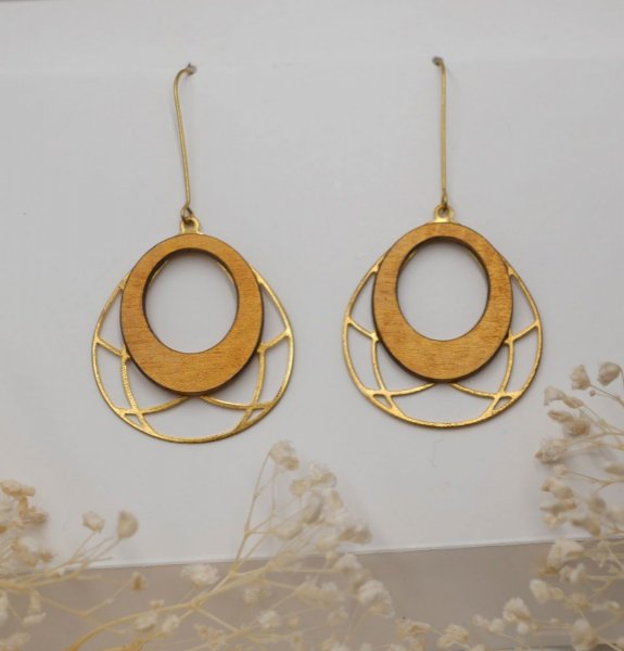 Vergulde ovale houten oorbellen aan opengewerkt messing kwastje