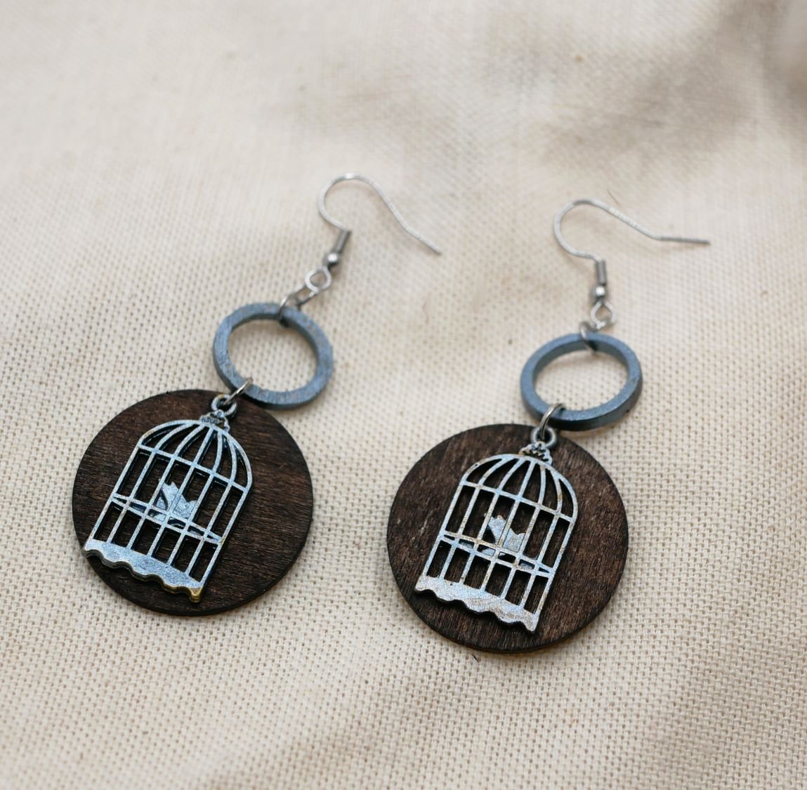 Grafische walnoothouten oorbellen met vogelkooi hanger