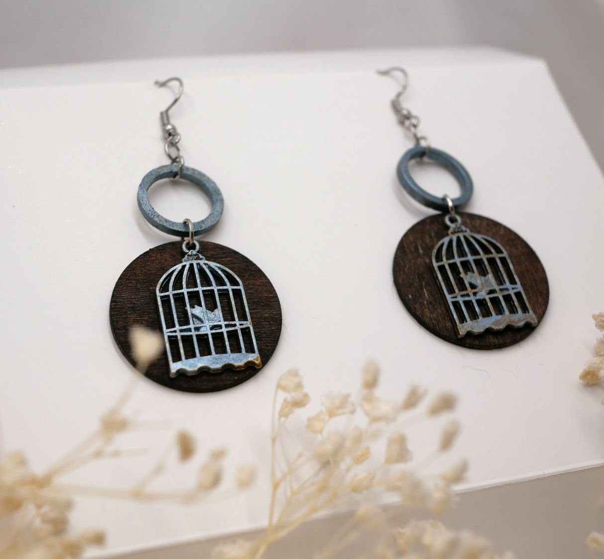 Grafische walnoothouten oorbellen met vogelkooi hanger