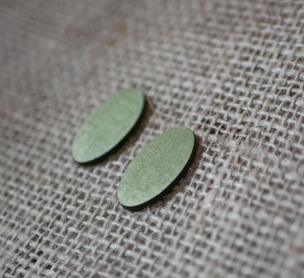 Ovale houten oorbellen geschilderd in een duo van groen met een metallic effect