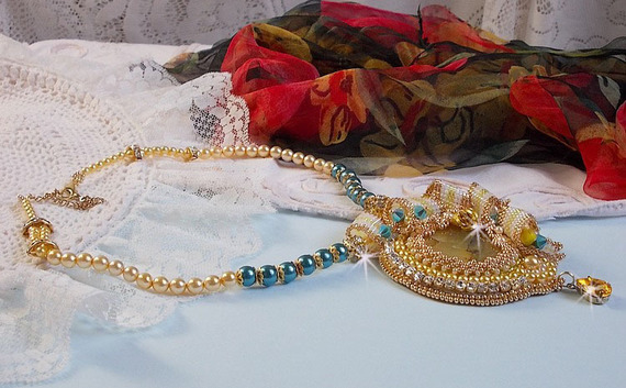 Haute-Couture Sunflower Gold hanger geborduurd met 24 karaats vergulde rocailles, een Madagaskar opaal en Swarovski kristallen.