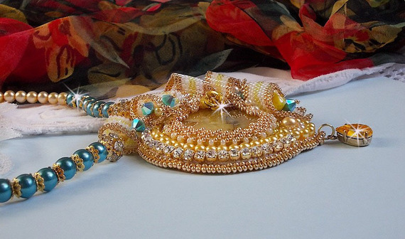 Haute-Couture Sunflower Gold hanger geborduurd met 24 karaats vergulde rocailles, een Madagaskar opaal en Swarovski kristallen.