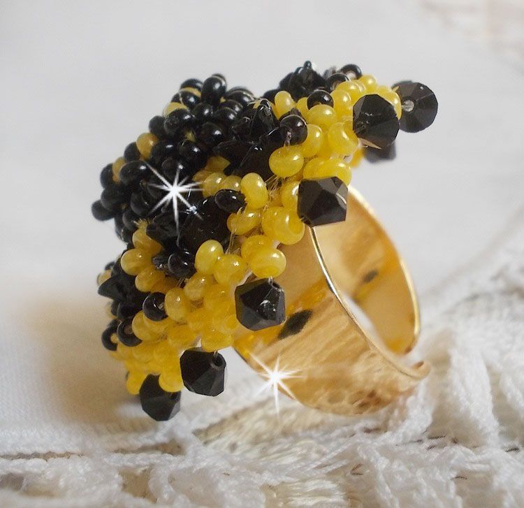 Dorine ring geborduurd met zwarte rozen cabochons, een kristallen ring en Jet en gele rocailles.