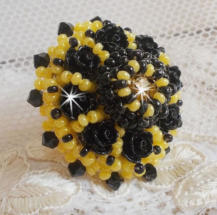Dorine ring geborduurd met zwarte rozen cabochons, een kristallen ring en Jet en gele rocailles.