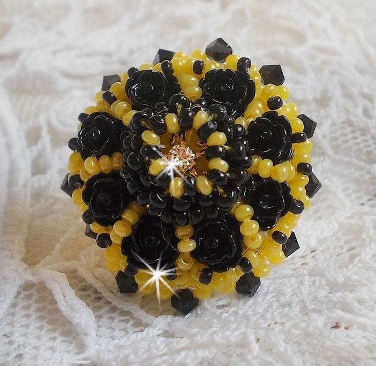 Dorine ring geborduurd met zwarte rozen cabochons, een kristallen ring en Jet en gele rocailles.