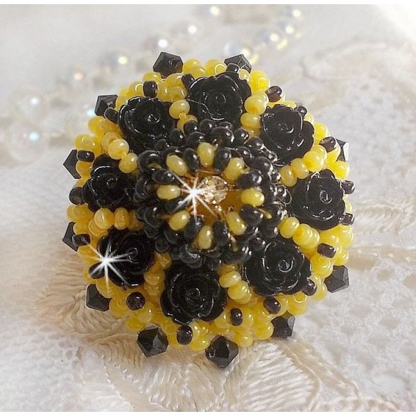 Dorine ring geborduurd met zwarte rozen cabochons, een kristallen ring en Jet en gele rocailles.