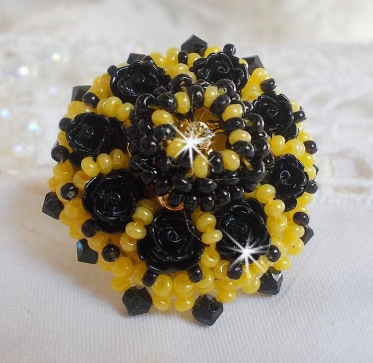 Dorine ring geborduurd met zwarte rozen cabochons, een kristallen ring en Jet en gele rocailles.