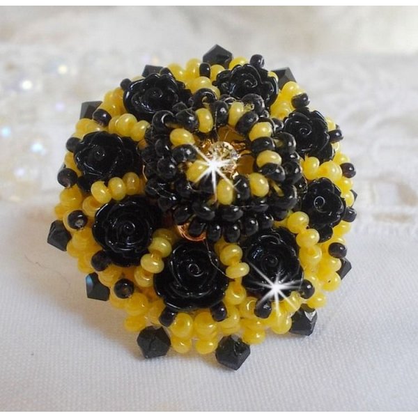 Dorine ring geborduurd met zwarte rozen cabochons, een kristallen ring en Jet en gele rocailles.
