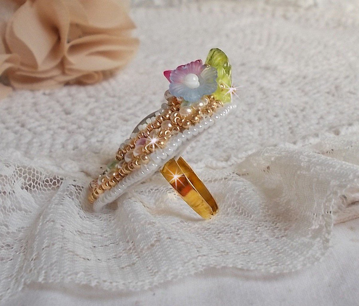 Envolée Fleurie ring geborduurd met een hars cabochon van Lucite bloemen, parels en rocailles.