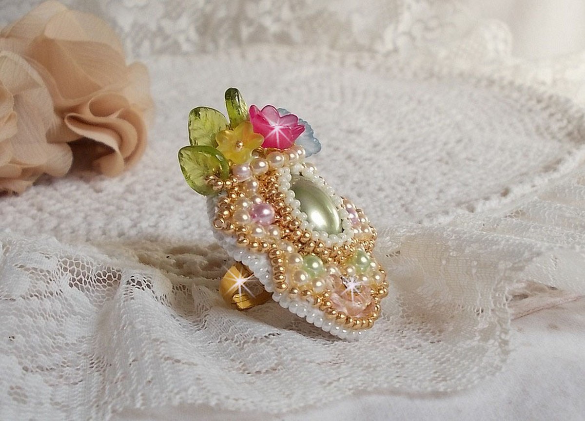 Envolée Fleurie ring geborduurd met een hars cabochon van Lucite bloemen, parels en rocailles.