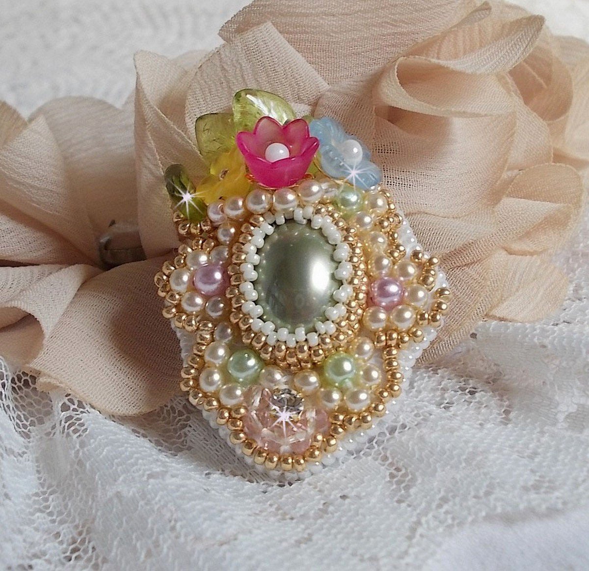 Envolée Fleurie ring geborduurd met een hars cabochon van Lucite bloemen, parels en rocailles.