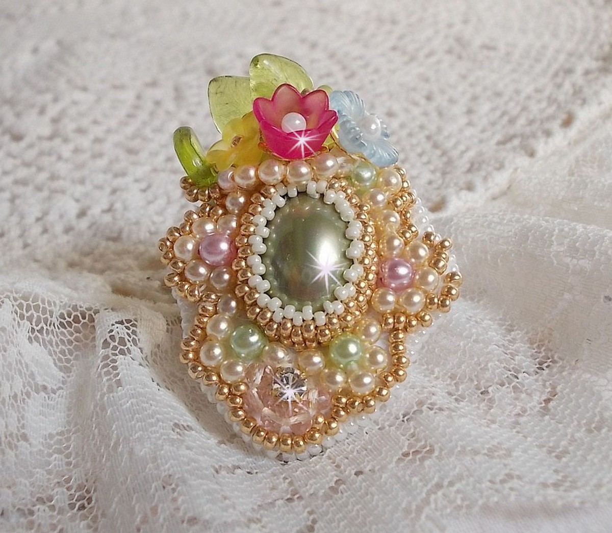 Envolée Fleurie ring geborduurd met een hars cabochon van Lucite bloemen, parels en rocailles.