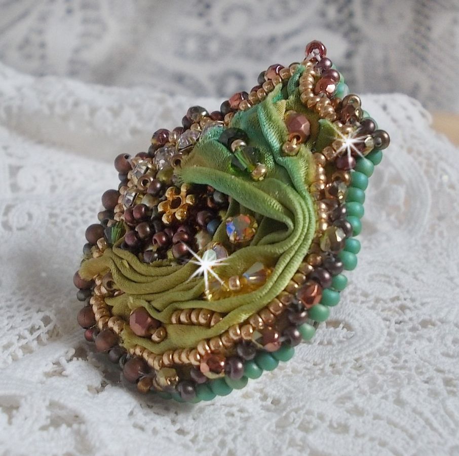 Venetiaanse maanring geborduurd met kameleonkleurig zijden lint, Swarovski kristallen, diverse parels en rocailles.