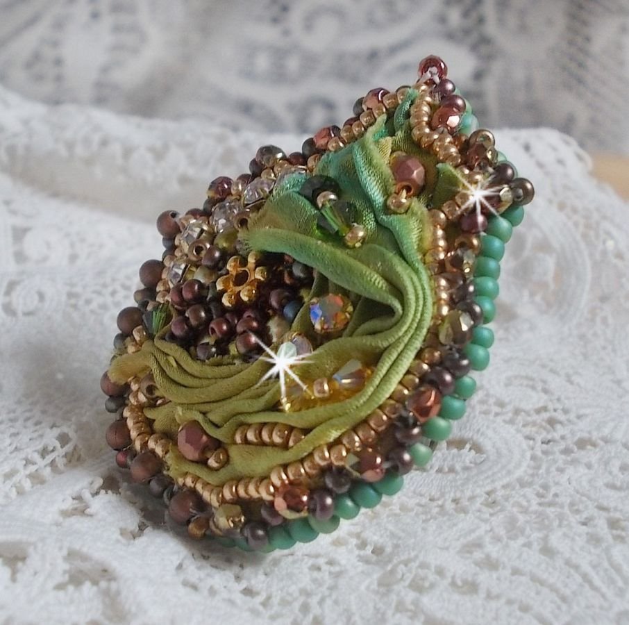 Venetiaanse maanring geborduurd met kameleonkleurig zijden lint, Swarovski kristallen, diverse parels en rocailles.