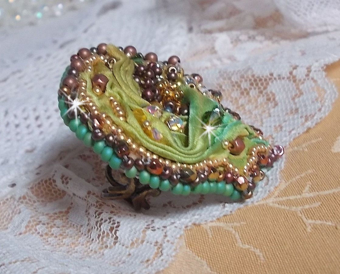 Venetiaanse maanring geborduurd met kameleonkleurig zijden lint, Swarovski kristallen, diverse parels en rocailles.