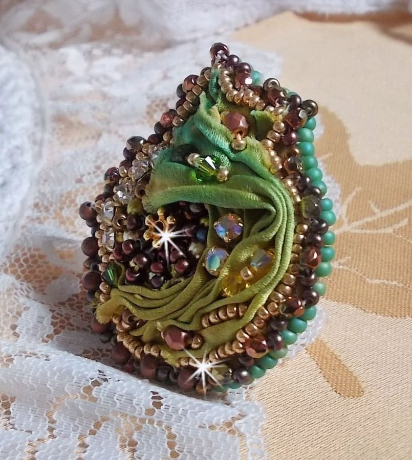 Venetiaanse maanring geborduurd met kameleonkleurig zijden lint, Swarovski kristallen, diverse parels en rocailles.