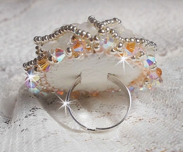 Bouquet d'un Jour ring geborduurd met lucite lelies, Swarovski kristallen tolletjes, een parelmoeren cabochon met zilveren en zalmkleurige rocailles.