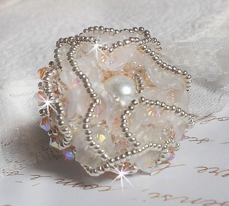 Bouquet d'un Jour ring geborduurd met lucite lelies, Swarovski kristallen tolletjes, een parelmoeren cabochon met zilveren en zalmkleurige rocailles.