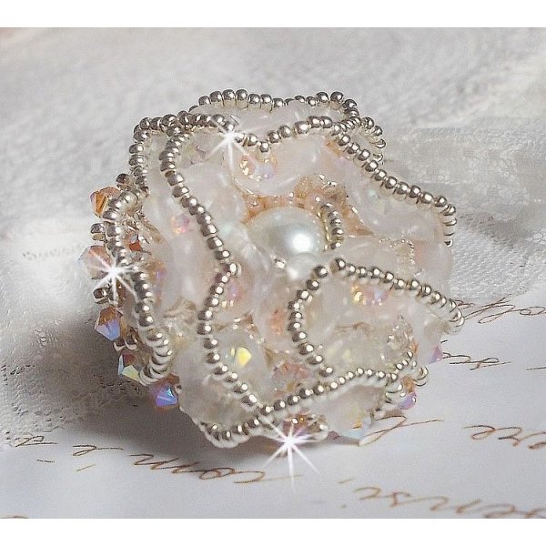 Bouquet d'un Jour ring geborduurd met lucite lelies, Swarovski kristallen tolletjes, een parelmoeren cabochon met zilveren en zalmkleurige rocailles.