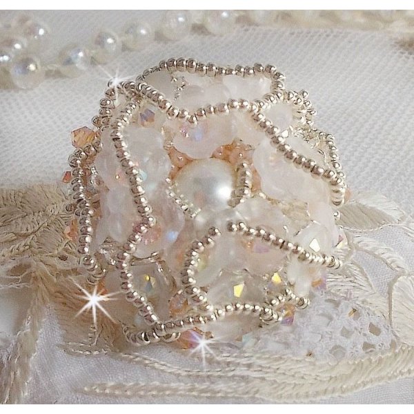 Bouquet d'un Jour ring geborduurd met lucite lelies, Swarovski kristallen tolletjes, een parelmoeren cabochon met zilveren en zalmkleurige rocailles.