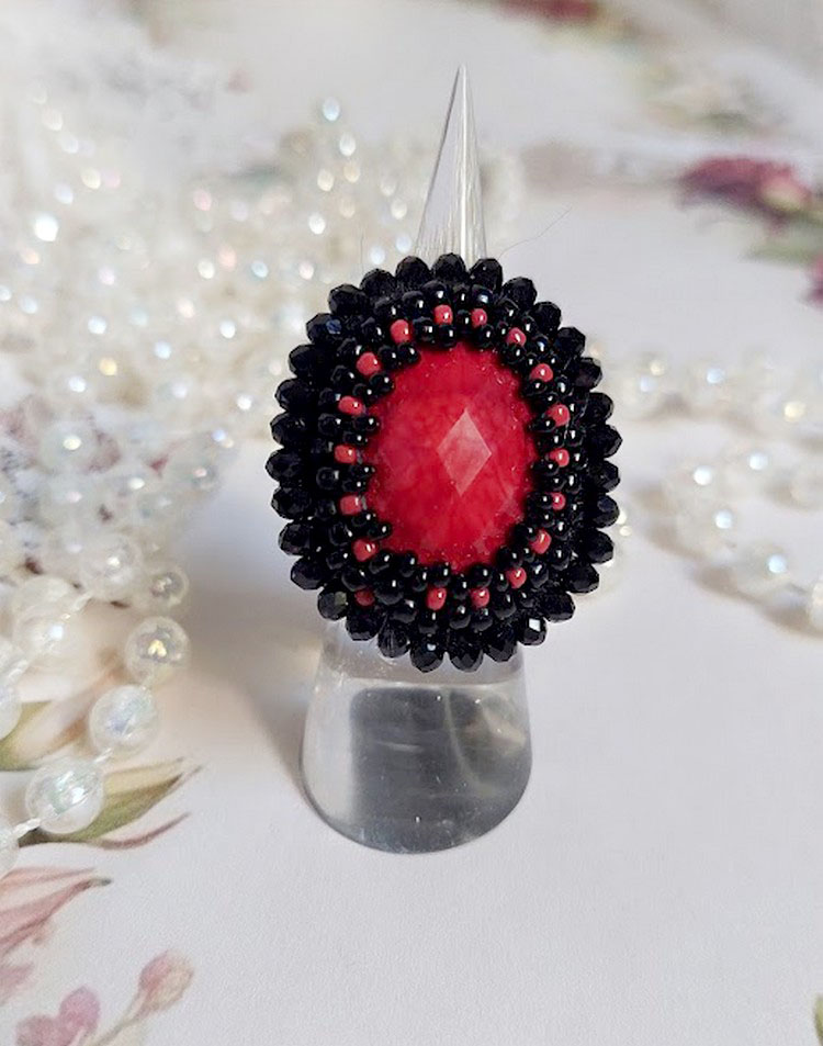 Midnight in Paris ring geborduurd met een rode facet geslepen cabochon en ronde zwarte parels