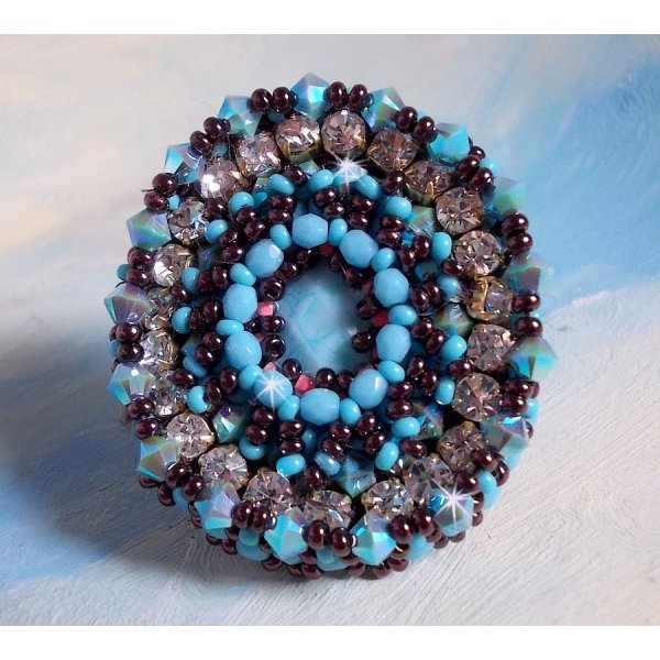 Na&iuml;ade ring geborduurd met een turquoise blauwe hars en kristal cabochon, een prachtig lichtspel.