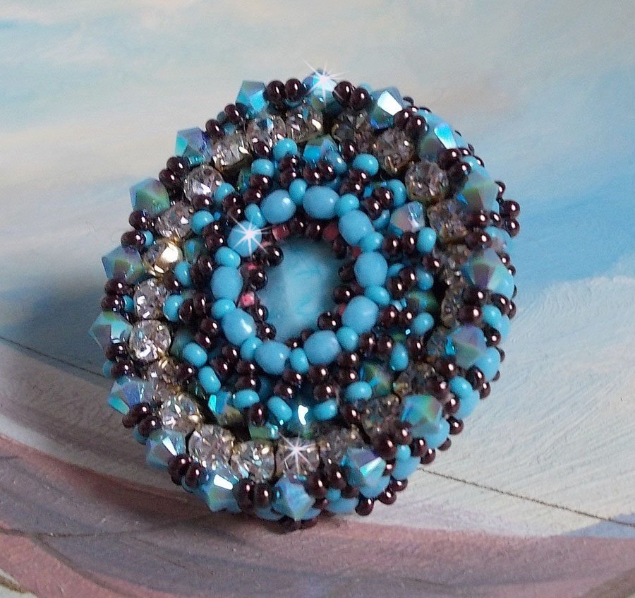 Naïade ring geborduurd met een turquoise blauwe hars en kristal cabochon, een prachtig lichtspel.