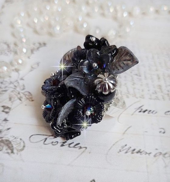 Bague Soir de Lune cr&eacute;&eacute;e avec des fleurs lucites Noires et Grises peintes &agrave; la main, cristaux, perles en r&eacute;sine, perles en verre et coupelle argent&eacute;e. Le tout est mont&eacute; sur une bague argent&eacute;e
