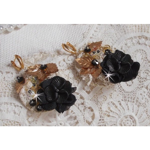 Zwarte en gouden vangers geborduurd met Swarovski-kristallen, stoffen bloemen en rocailles.