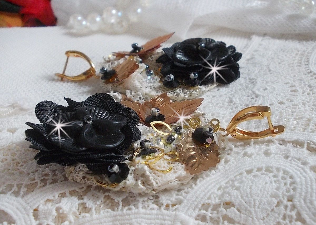 Zwarte en gouden vangers geborduurd met Swarovski-kristallen, stoffen bloemen en rocailles.