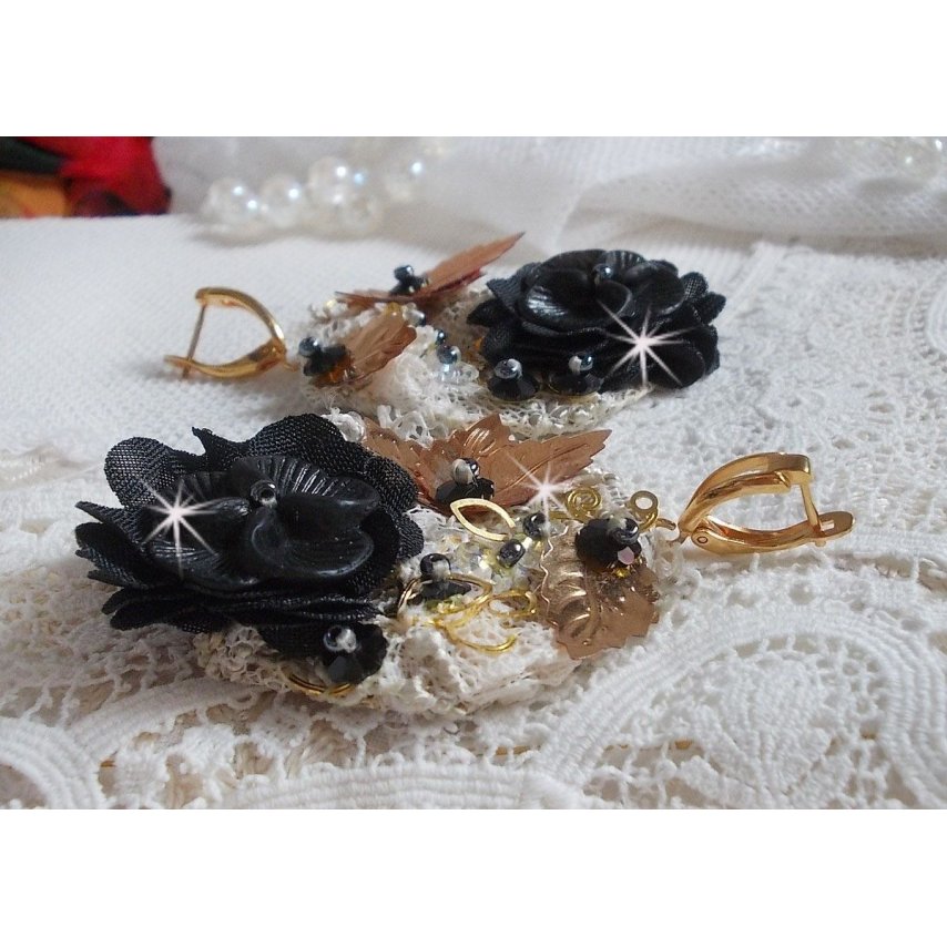Zwarte en gouden vangers geborduurd met Swarovski-kristallen, stoffen bloemen en rocailles.