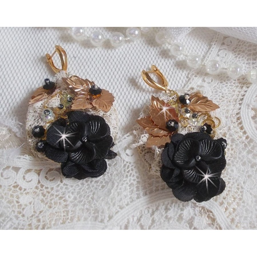 Zwarte en gouden vangers geborduurd met Swarovski-kristallen, stoffen bloemen en rocailles.