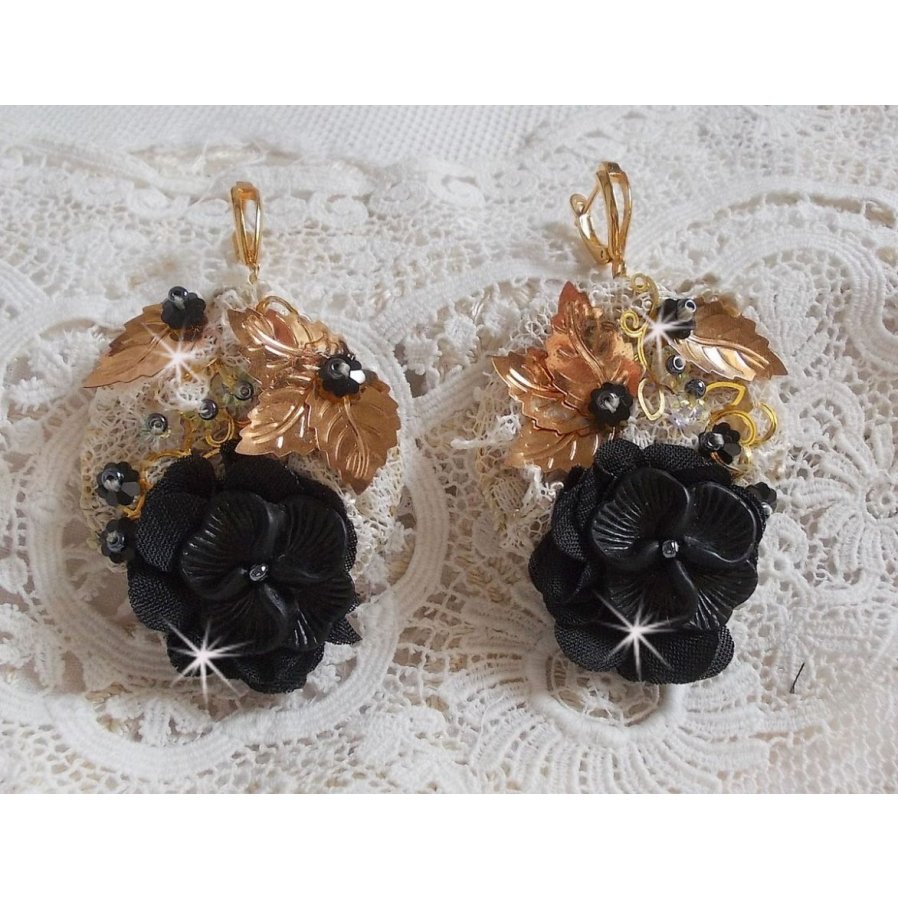 Zwarte en gouden vangers geborduurd met Swarovski-kristallen, stoffen bloemen en rocailles.