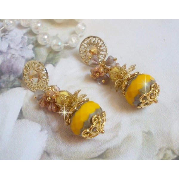 BO Lumi&egrave;re Opale Jaune avec des perles potirons jaunes &agrave; laquelle s&rsquo;ajoute des fleurs, cabochons en cristal, coupelles et perles rondes. Mont&eacute;s sur clous d&rsquo;oreilles en M&eacute;tal. Un style moderne