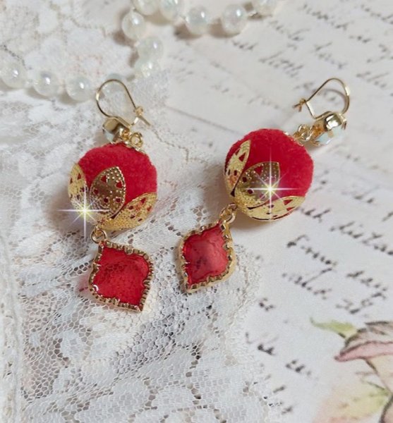 BO Passionn&eacute;ment mont&eacute;es avec des pompons Rouges tr&egrave;s tendances &agrave; laquelle s&rsquo;ajoute des coupelles en forme d&rsquo;arabesque, pendentifs vitrail Rouge/Dor&eacute; et cabochons en Cristal AB sur crochets en Laiton