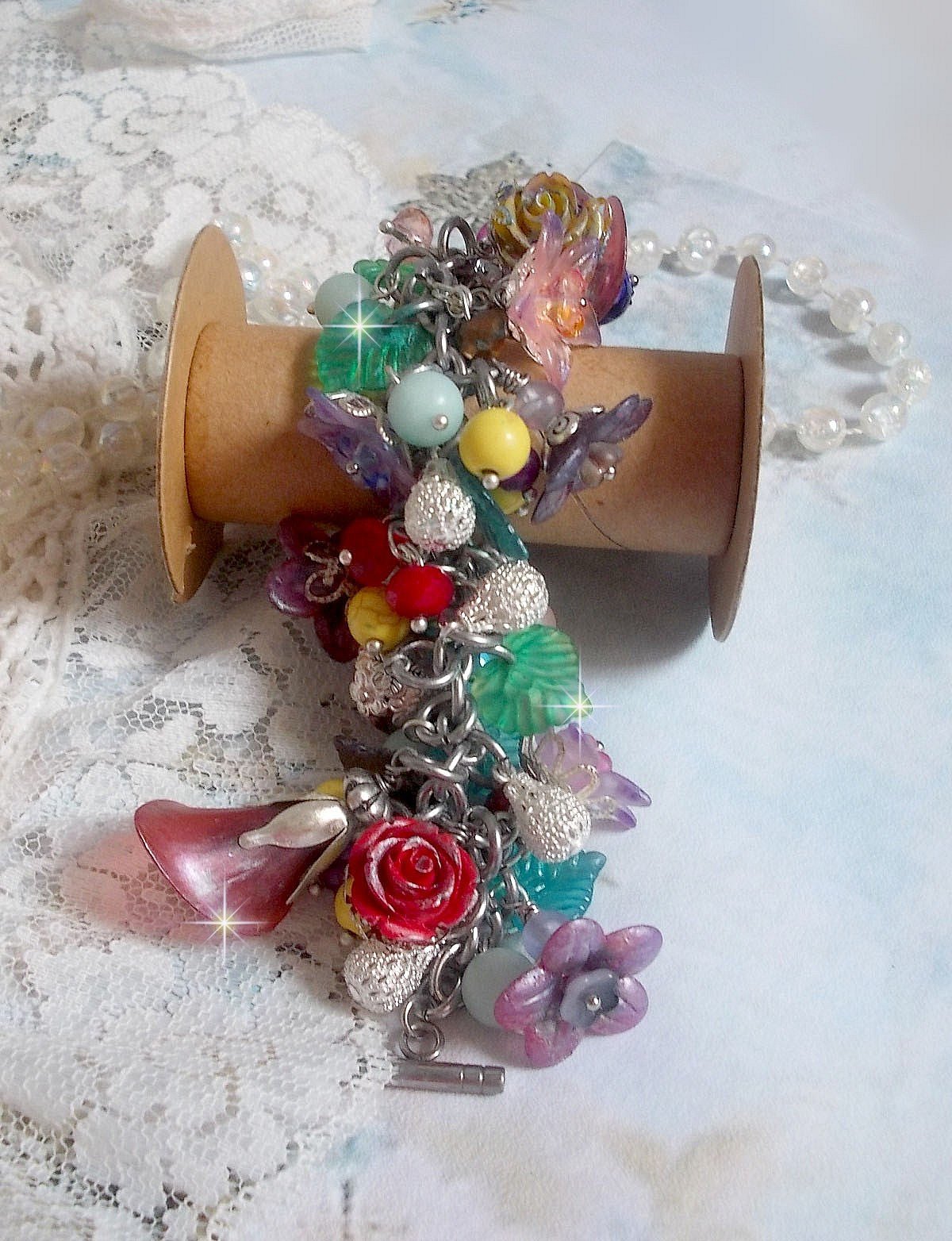 Bracelet Lady Luxe mont&eacute; avec des perles de gemme : L&rsquo;Amazonite et la Sugilite &agrave; laquelle s&rsquo;ajoute des fleurs de diff&eacute;rentes vari&eacute;t&eacute;s peintes &agrave; la main : lucite et r&eacute;sine, breloques et perles