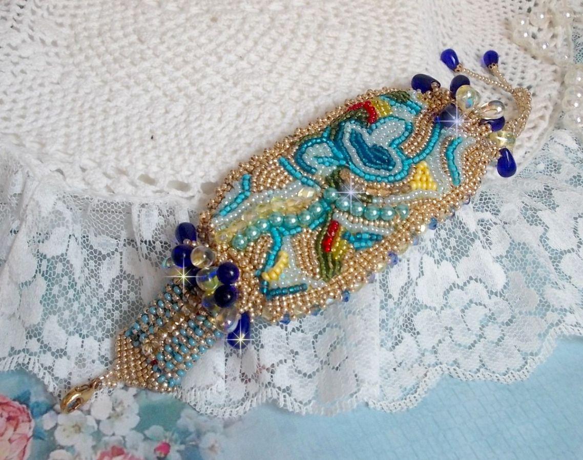 Blauw Gouden Vlinder armband geborduurd met Swarovski kristallen; gladde druppels, facetten, rocailles en een 14 karaat Gold Filled sluiting.
