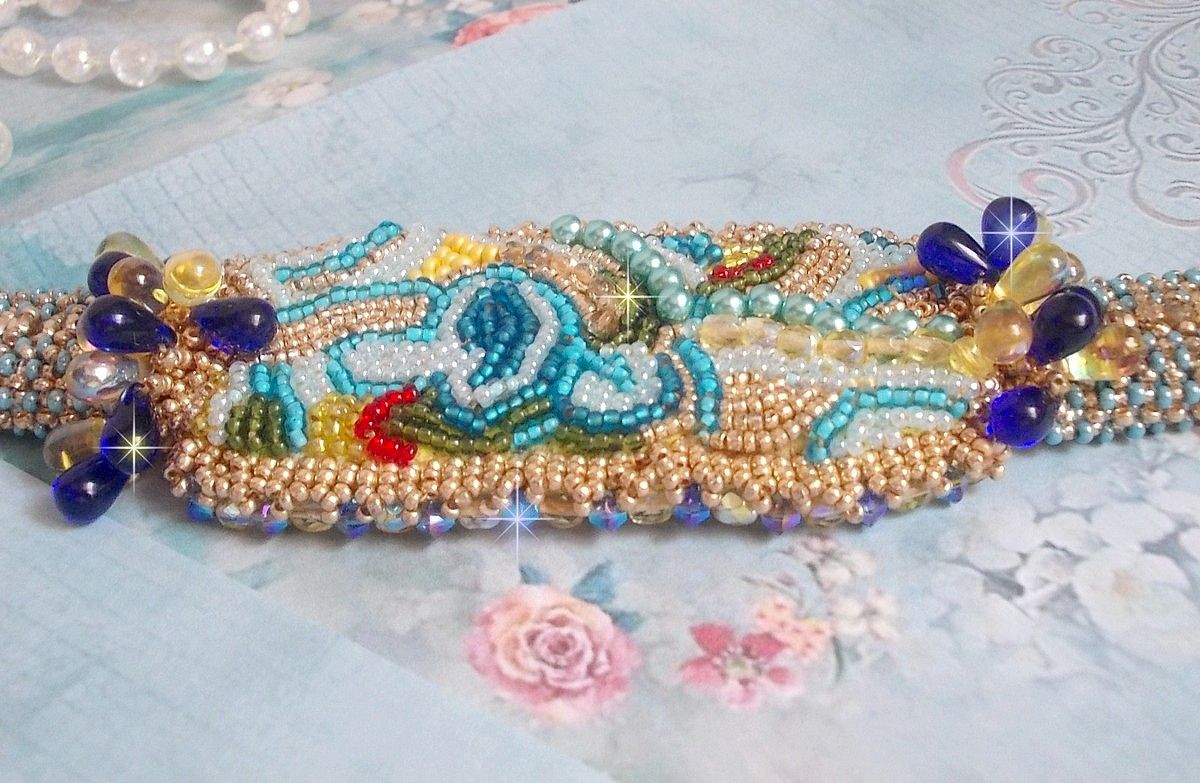 Blauw Gouden Vlinder armband geborduurd met Swarovski kristallen; gladde druppels, facetten, rocailles en een 14 karaat Gold Filled sluiting.