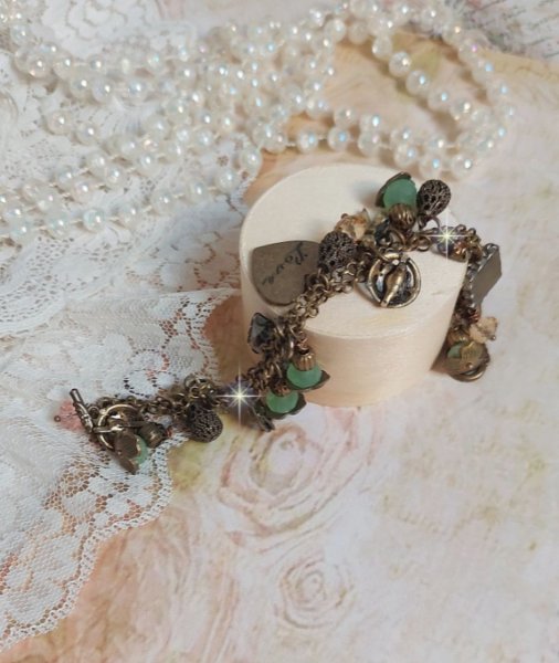 Bracelet Temps d&rsquo;une Folie avec breloques : c&oelig;ur, perles, gouttes filigran&eacute;es, fleurs &eacute;maill&eacute;es, perles rondes, cabochons carr&eacute;s et perles rondes en Verre. Mont&eacute;s sur cha&icirc;nes et fermoir en T Bronze